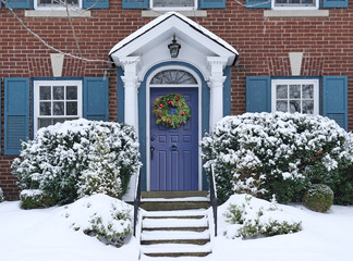 Wall Mural - Front door of snow covered house with Christmas wreath