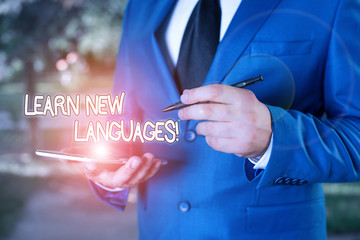 Wall Mural - Writing note showing Learn New Languages. Business concept for developing ability to communicate in foreign lang Businessman holds laptop and pen pointing into the copy space