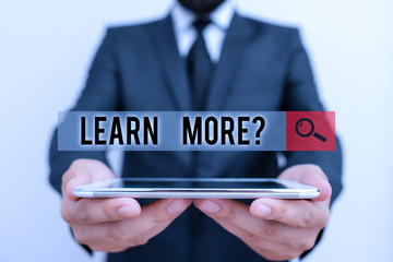 Poster - Text sign showing Learn More question. Business photo text gain knowledge or skill studying practicing Male human wear formal work suit hold smart hi tech smartphone use hands