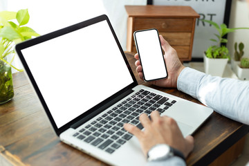 mockup image blank screen computer,cell phone with white background for advertising text,hand man using laptop texting mobile contact business search information on desk in office.marketing and design