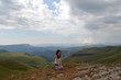 © Prozhekter  - Beautiful mountain valley and young woman on the rock in mountain