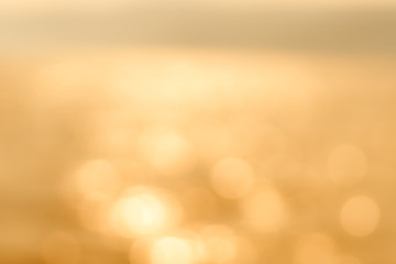 Delicate golden texture bokeh background. blurry yellow bokeh glare on the water during sunset and dawn