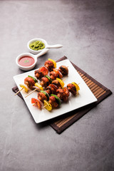 Wall Mural - Barbecue or tandoori Mushroom Tikka, served in a plate with green chutney and ketchup. selective focus