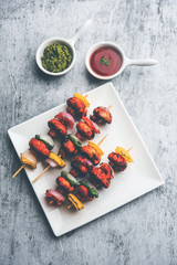 Wall Mural - Barbecue or tandoori Mushroom Tikka, served in a plate with green chutney and ketchup. selective focus