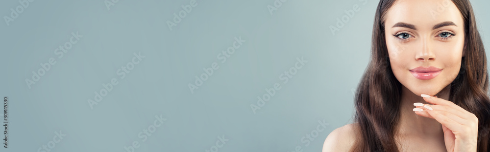 Portrait of young smiling woman with long brown hair and clear skin on blue banner background - obrazy, fototapety, plakaty 