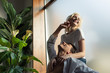 © LIGHTFIELD STUDIOS - Shirtless man touching smiling girlfriend beside window in living room