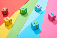 Multicolored Gift Boxes Scattered On Rainbow Background