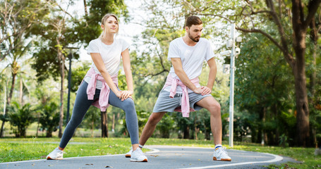 Men and women are Caucasian couples wearing sportswear. Come to workout at the park in morning Resulting in good health There are surveillance cameras for the safety of people exercising. copy space