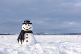Fototapeta Na sufit - Funny snowman in stylish hat and black scalf on snowy field. Merry Christmass and happy New Year!