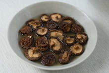 Dried Shiitake Mushrooms Soaking And Rehydrating In A Bowl Of Hot Water