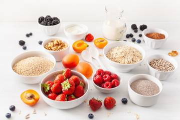 Wall Mural - variaty of raw cereals, fruits and nuts for breakfast. Oatmeal flakes and steel cut, barley, walnut, chia, apricot, strawberry. Healthy ingredients