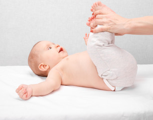 little baby receiving leg massage in pediatric clinic
