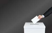Hand Of A Person Use A Vote Into The Ballot Box In Elections. With Black Background