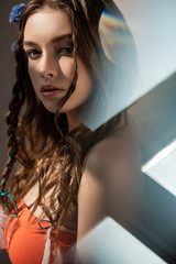 Wall Mural - beautiful ethnic girl with braids in hairstyle posing on grey with lens flares