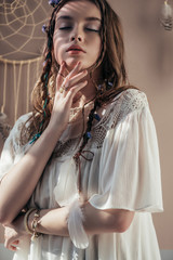 Wall Mural - tender girl with braids and closed eyes on beige with dream catcher