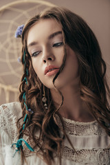 Wall Mural - attractive tender girl with braids in white boho dress on beige with dream catcher
