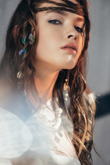Wall Mural - confident boho girl with braids in hairstyle posing on grey with lens flares