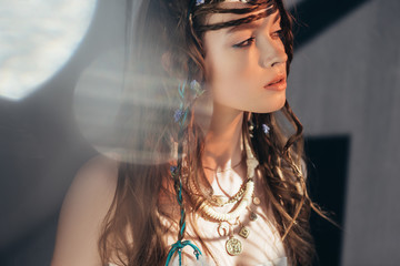 Wall Mural - beautiful boho girl with braids in hairstyle posing on grey with lens flares