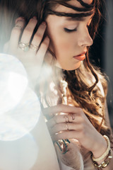 Wall Mural - tender boho girl with braids in hairstyle posing on grey with lens flares