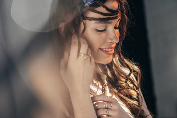 Wall Mural - happy boho girl with braids in hairstyle posing on grey with lens flares