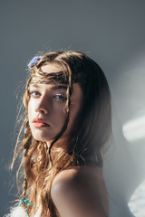 Wall Mural - young naked boho girl with braids in hairstyle posing on grey with lens flares