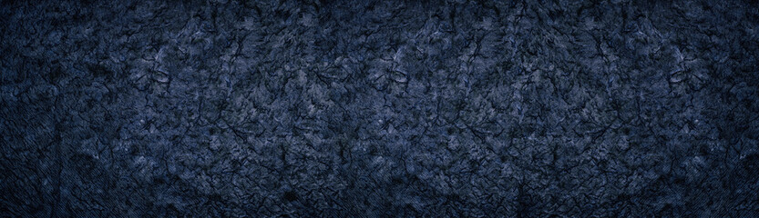 Dark deep blue wide background. Rough crumpled surface large panoramic texture