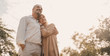 © Yingyaipumi - Romantic and elderly healthy lifestyle concept.Senior active caucasian couple holding hands looks happy in the park in the afternoon autumn sunlight,happy anniversary,happily retired with copy space.