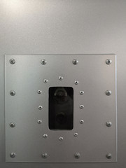 Poster - Vintage video camera hidden behind steel panels. Mecanical engineering pattern with bolts and rivets around the perimeter. Abstract industrial template with metal powder coating texture background.