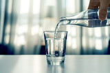 Fototapeta  - Nalewanie oczyszczonej świeżej wody do picia z butelki na stole w salonie