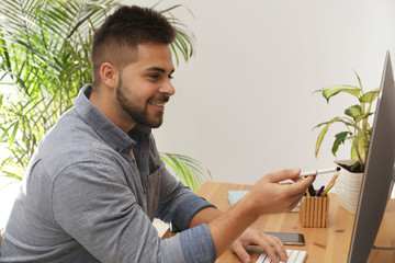 Poster - Young man using computer at table in office