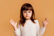 © Marharyta Hanhalo - No, it's not mine! I don't know! Funny cute emotional girl child showing perplexity gesture, puzzle emotion on face, palms up, unknown confused expression. One child over orange background