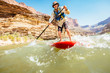 © Tandem Stock - A man paddles a stand up paddleboard along Stephen Aisle on the Colorado River, Grand Canyon National Park, Arizona, USA