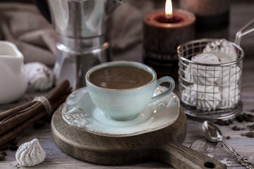 Cup of coffee Crema with chocolate chip cookies, marshmallows and burning candles.