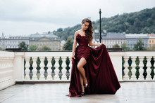 Charming Tender Princess In Long Shiny Satin Flying Waving Dress With Neckline, Girl Stands Ourdoor, Evening Lady Image On Graduation Party, Prom, Cute Make Up. Fashion Gorgeous Woman