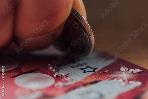 Cuadros en Lienzo close up view of silver coin in hand of gambler scratching lottery ticket