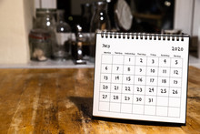 July 2020 Calendar - Month Page On Wooden Table In The Kitchen