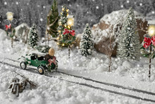 Miniature Classic Car Carrying A Christmas Tree On Snowy Road On Winter