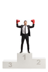 Poster - Man in a black suit and red boxing gloves standing on a first place of a winners pedestal