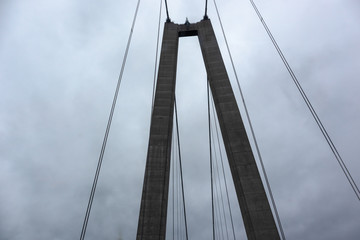 Bridge wire arch on dark dramatic skyscape heavy dark clouds. Swedish highroad northern architecture