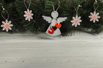 christmas card: rustic white wooden angel and snowflakes on christmas tree