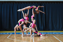 Cheerleader Group Perform Trick, Smiling Beautiful Girls In Black And Pink Sportswear Shows Off Their Moves, Dancers Hold The Girl In Their Arms