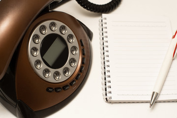 phone handset and notebook on a white background