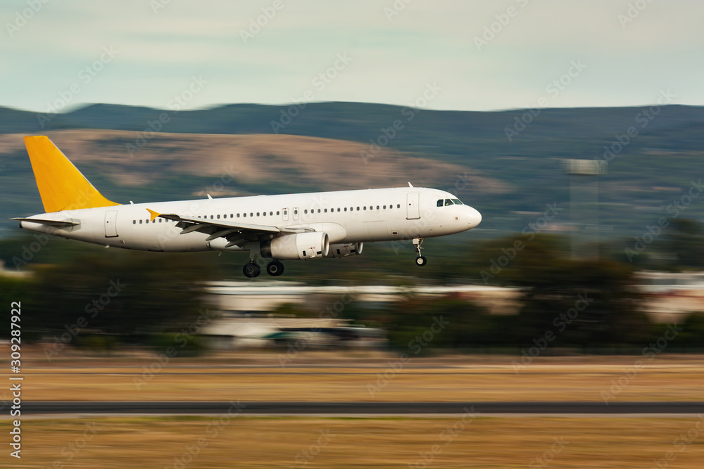 Panning shot of passenger airplane landing on runaway - obrazy, fototapety, plakaty 