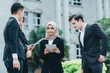 © amirul syaidi - Group of young executive people in formalwear holding tablet and discussing something