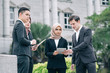 © amirul syaidi - Group of young executive people in formalwear discussing something and gesturing