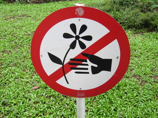 Road red prohibited from removing or pull out plants signs, isolated on grass garden background. Do not tear flower, informative warning. Don't pick or spoil flowers. No tearing plant.