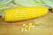 Tutu of corn peeled on a wooden board with grains.