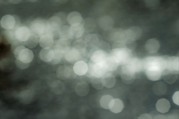 Defocused bokeh, dark background. Ripples on the water.