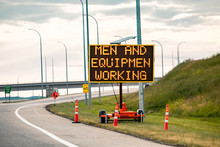 Temporary Condition Variable Message Sign With Orange Barrels On The Right Roadside Men And Equipment Working, Work Zone On The Canadian Highway Roads