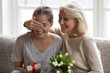 © fizkes - Senior mom making birthday present to adult daughter